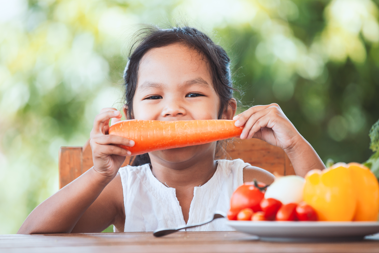 Asian child eating vegetables